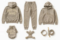A coordinated dog apparel set laid out on a white background, including a hoodie, sweatpants, a small hoodie, a harness, a collar, and a leash. The pieces are all in a warm taupe/beige tone with cream text branding reading 'Doggy Style Society.